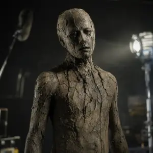 Fotorealistyczna scena horroru z humanoidalnym potworem z gliny na planie filmowym